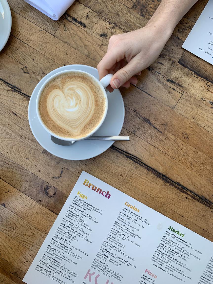 latte next to open menu on wooden table