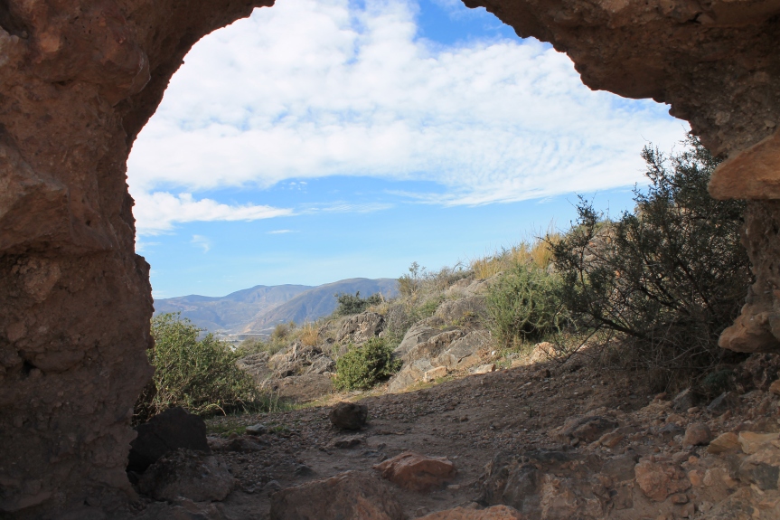 looking through ruins to mountains and blue sky