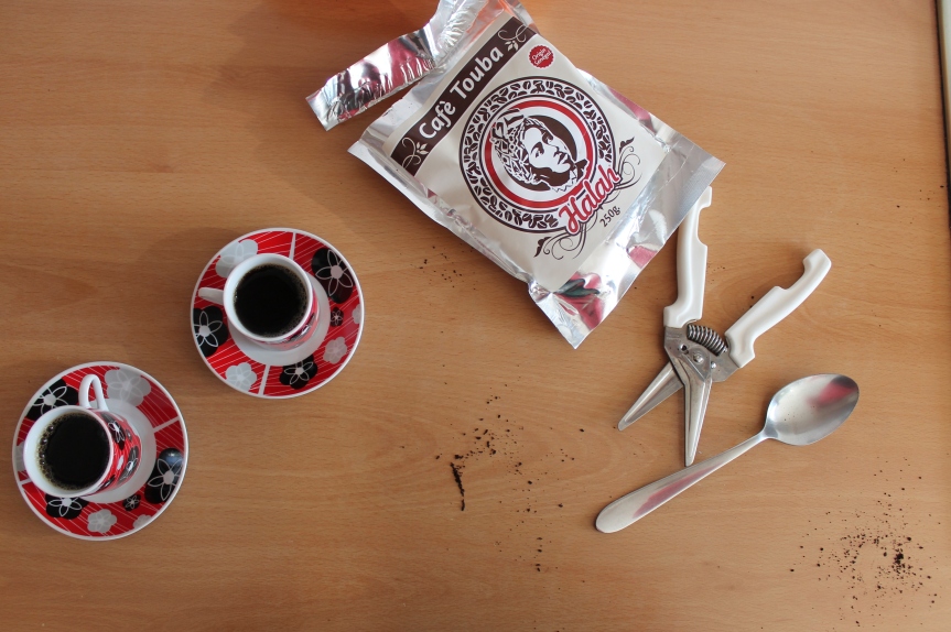 small coffee cups beside bag of coffee and scissors